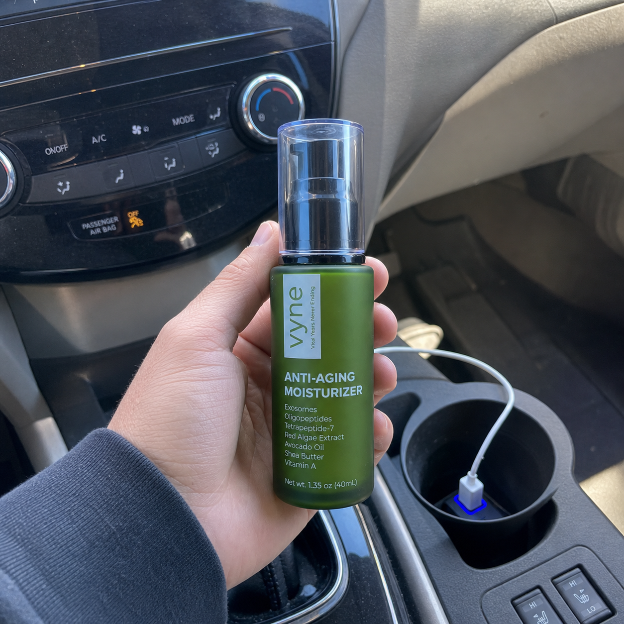 Customer holding VYNE moisturizer in a car